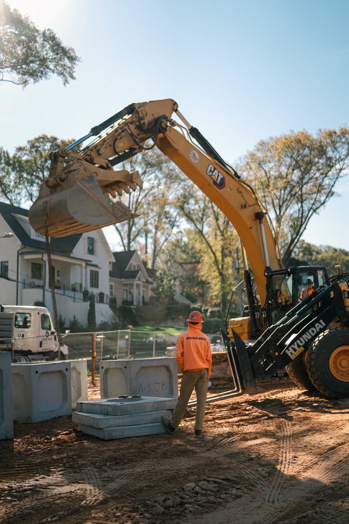 Alexander Grading crew member guiding an excavator on site