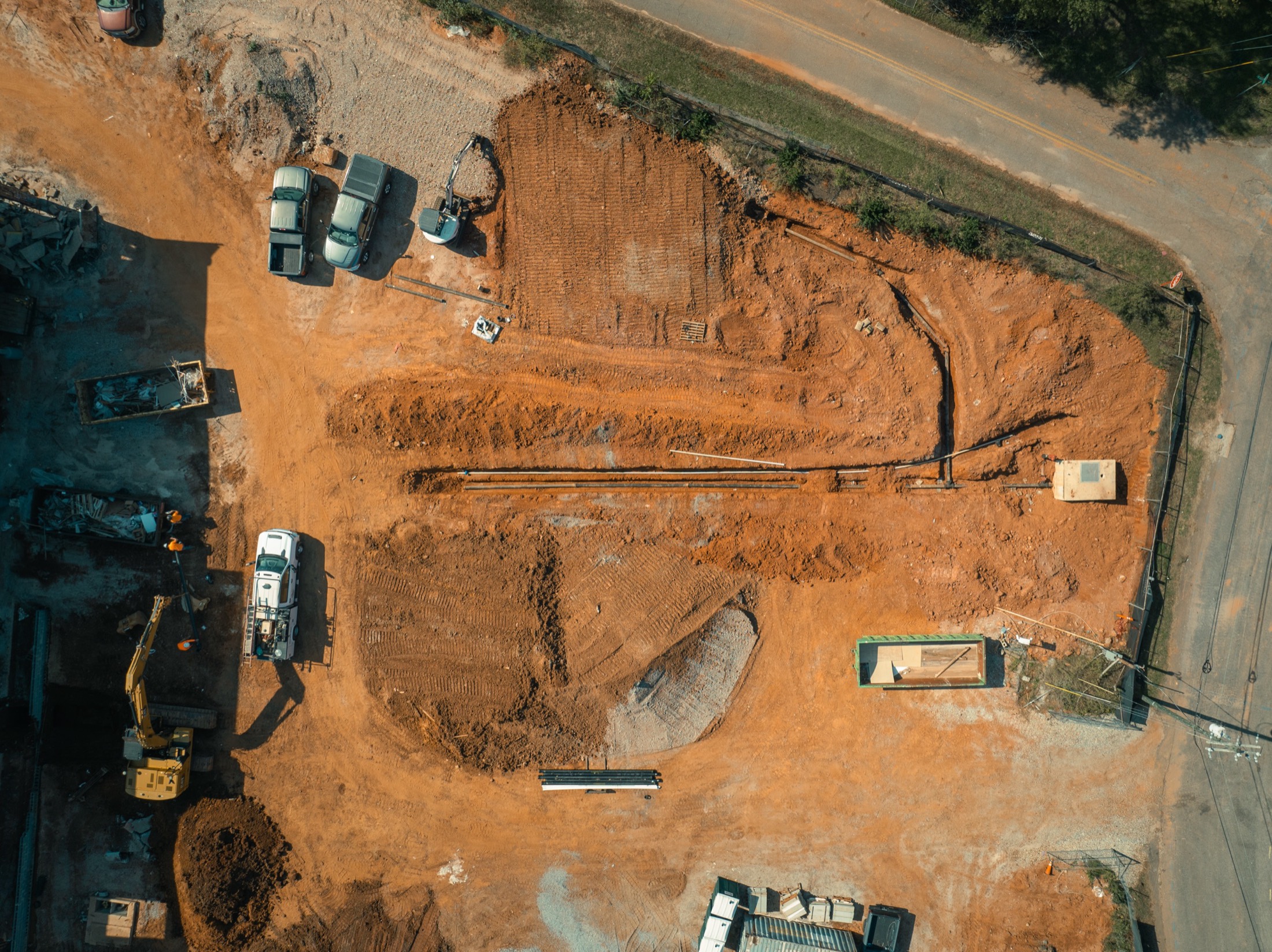 Top-down aerial of graded red clay site